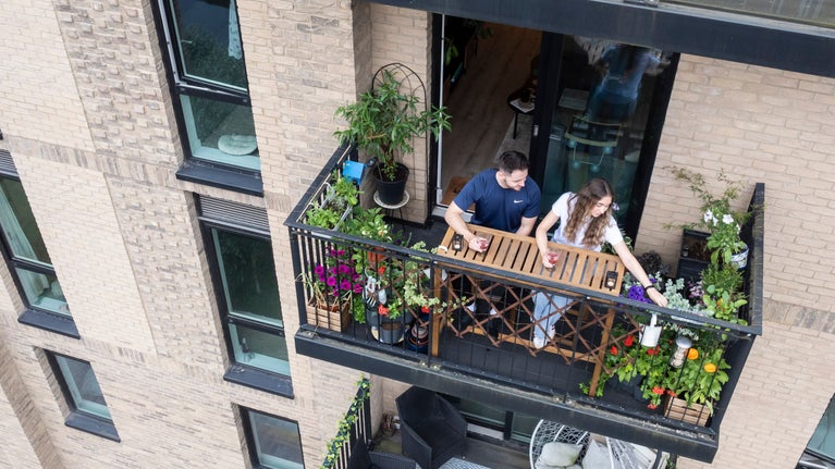 Image of a balcony from Sky Gardening Challenge 2024 Pilot. Drone shot from above, balcony with lots of plants on it.
